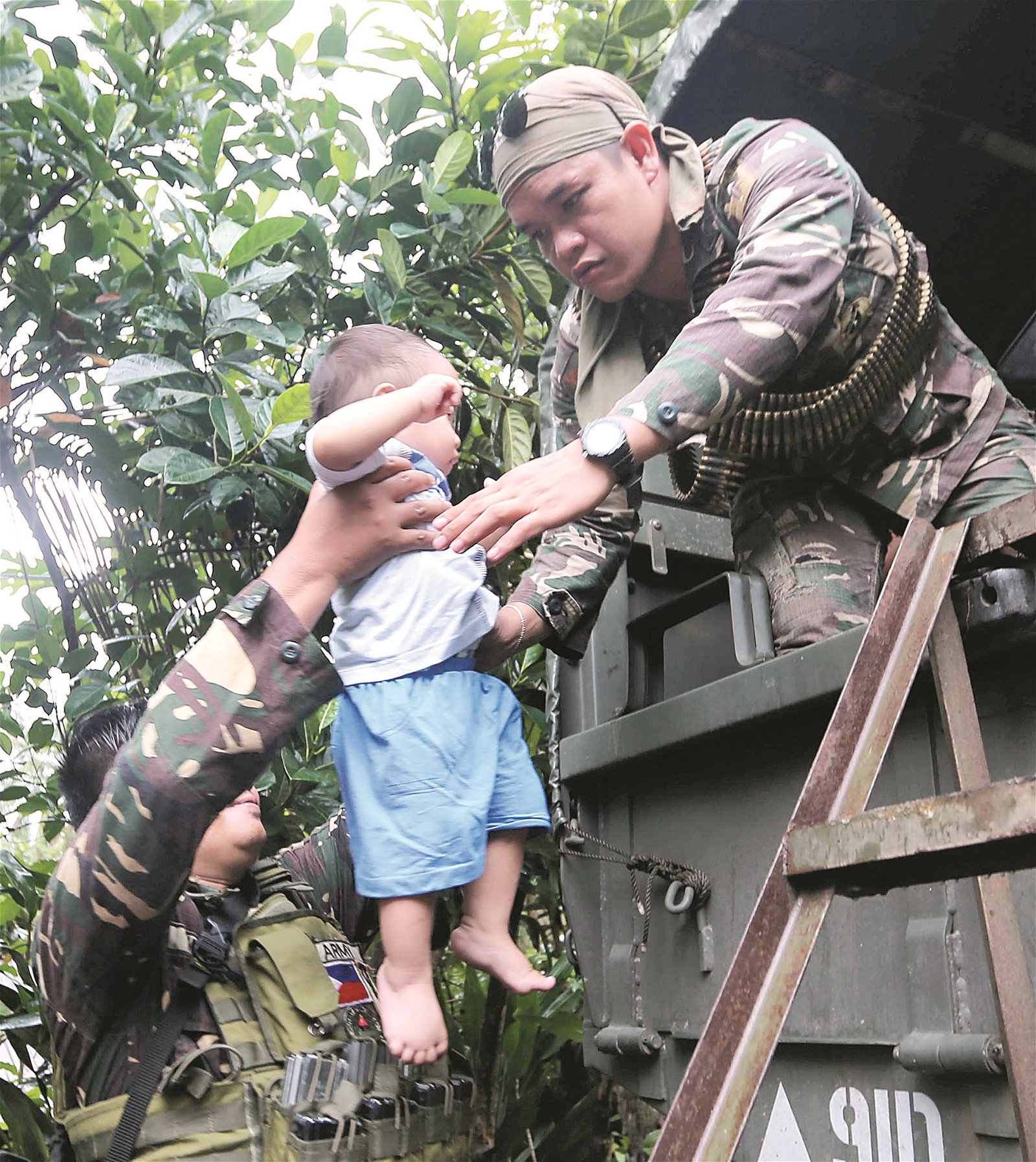 有灾难来临时，军人义不容辞伸出援手，图为一名军人协助把小孩抱上军车。