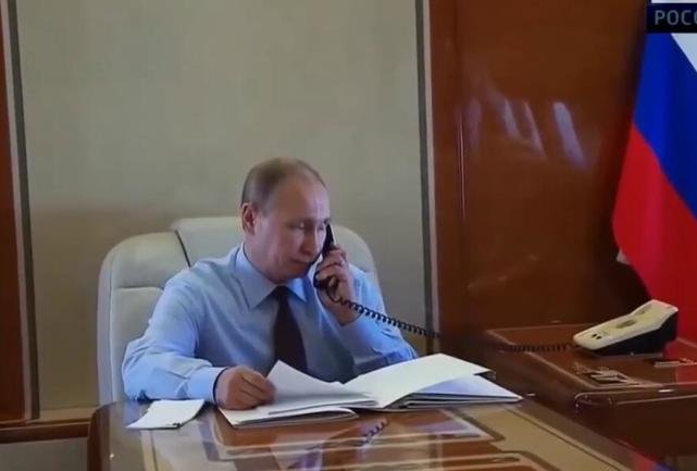 普京在专机会议室内使用卫星电话通信。