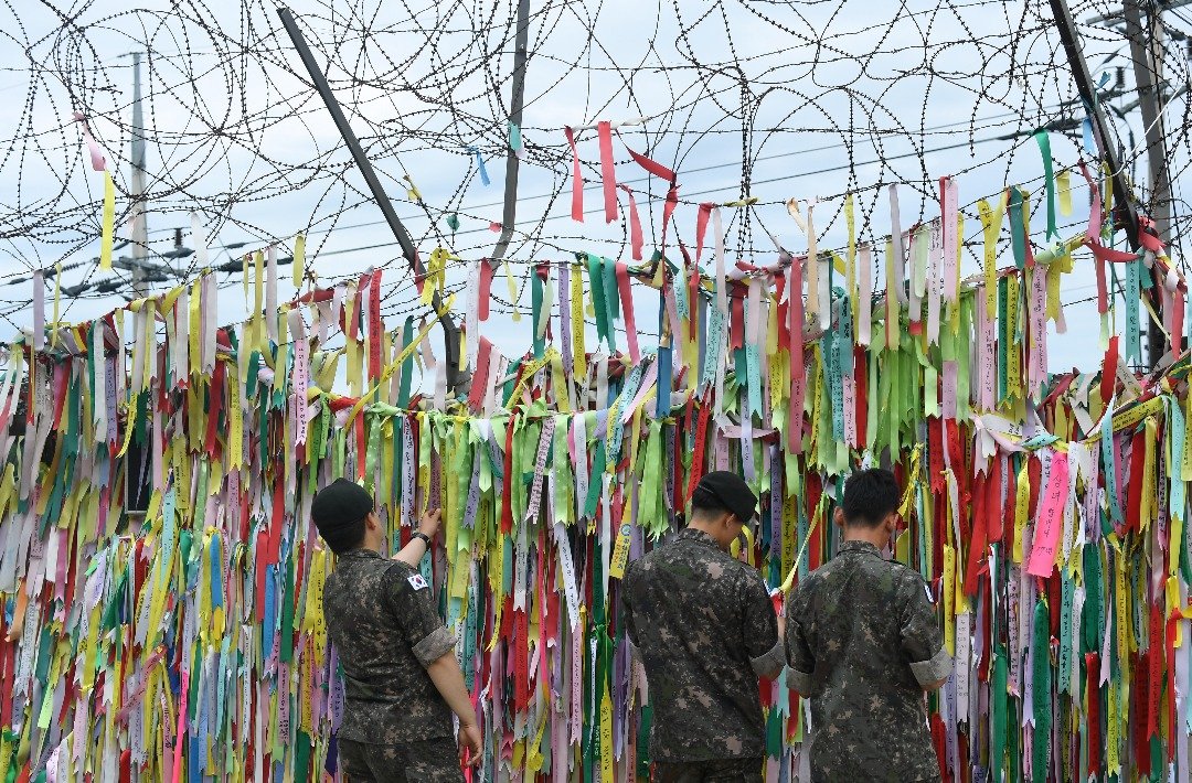 在划分韩朝半岛的韩方一侧边界城市坡州，韩国士兵们看著系在临津阁和平公园军事篱笆上呼吁和平与统一的彩色缎带。