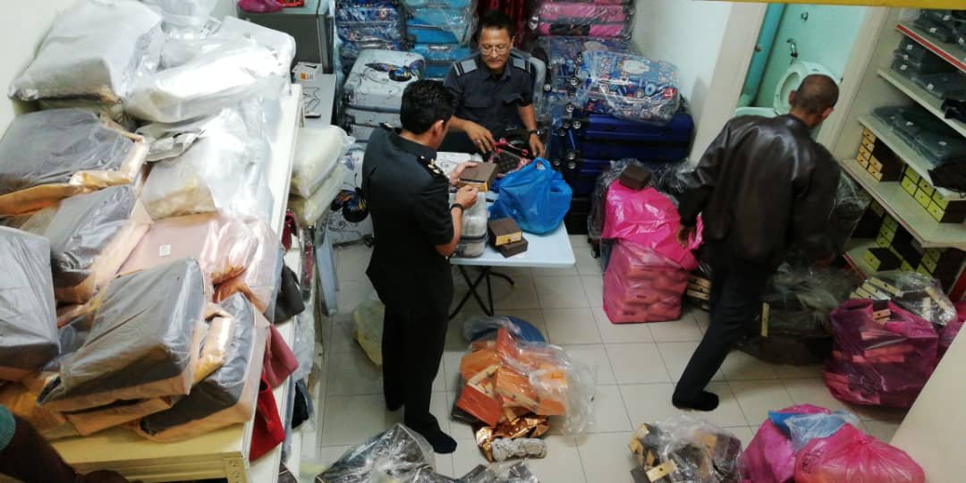 贸消局执法官员正在清算起获的各类膺品。
