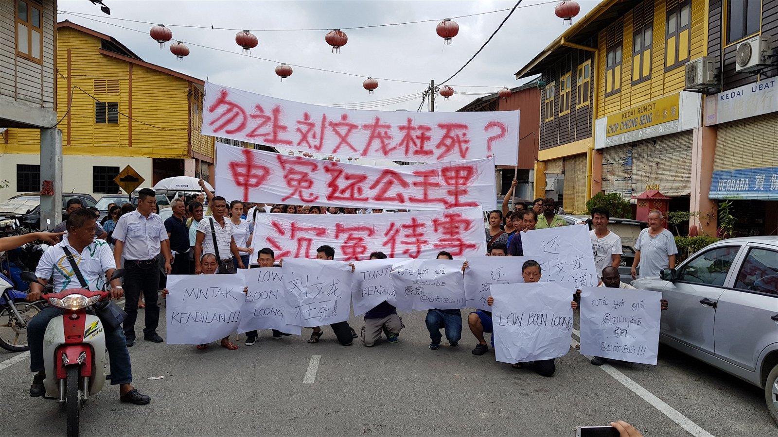 刘文龙的亲友在美冷车站新村送殡时，高举横幅及大字报，誓为死者讨回公道。