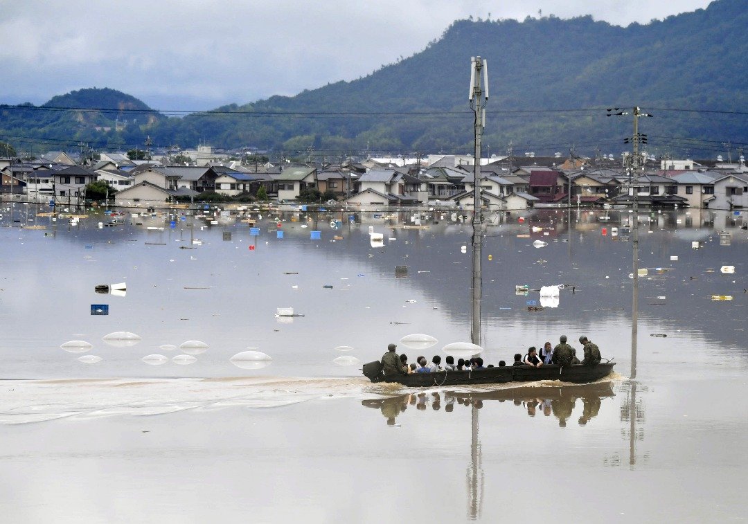 日本多个地区出现连日大雨，酿成水灾。在西日本的冈山县仓敷市，住宅区严重水淹，日本自卫队成员周六用船只将灾民载到安全的地方。