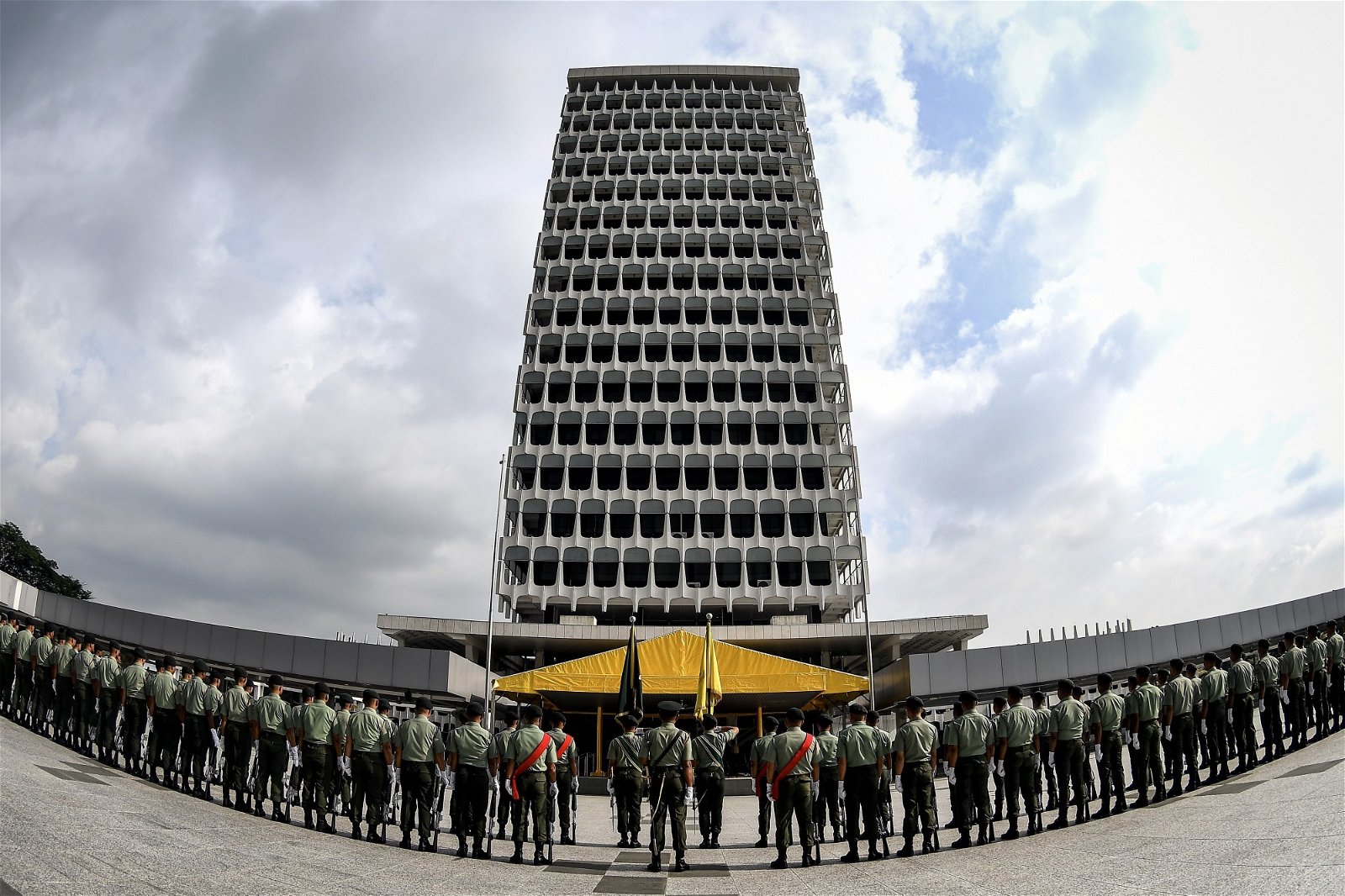 皇家马来兵团一字排开，站在高耸的国会大厦 前，不畏烈日进行排练，为即将举行的国会开幕 礼做好准备。