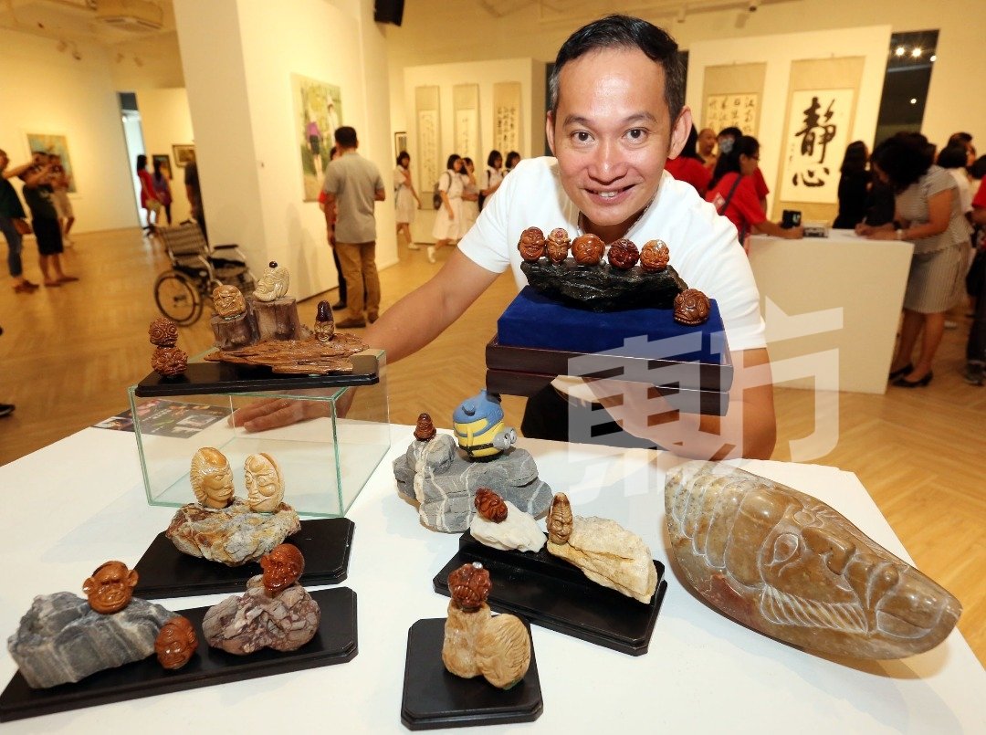 陈松俊展示以鳄梨果种子所雕刻的作品。（摄影：刘维杰）