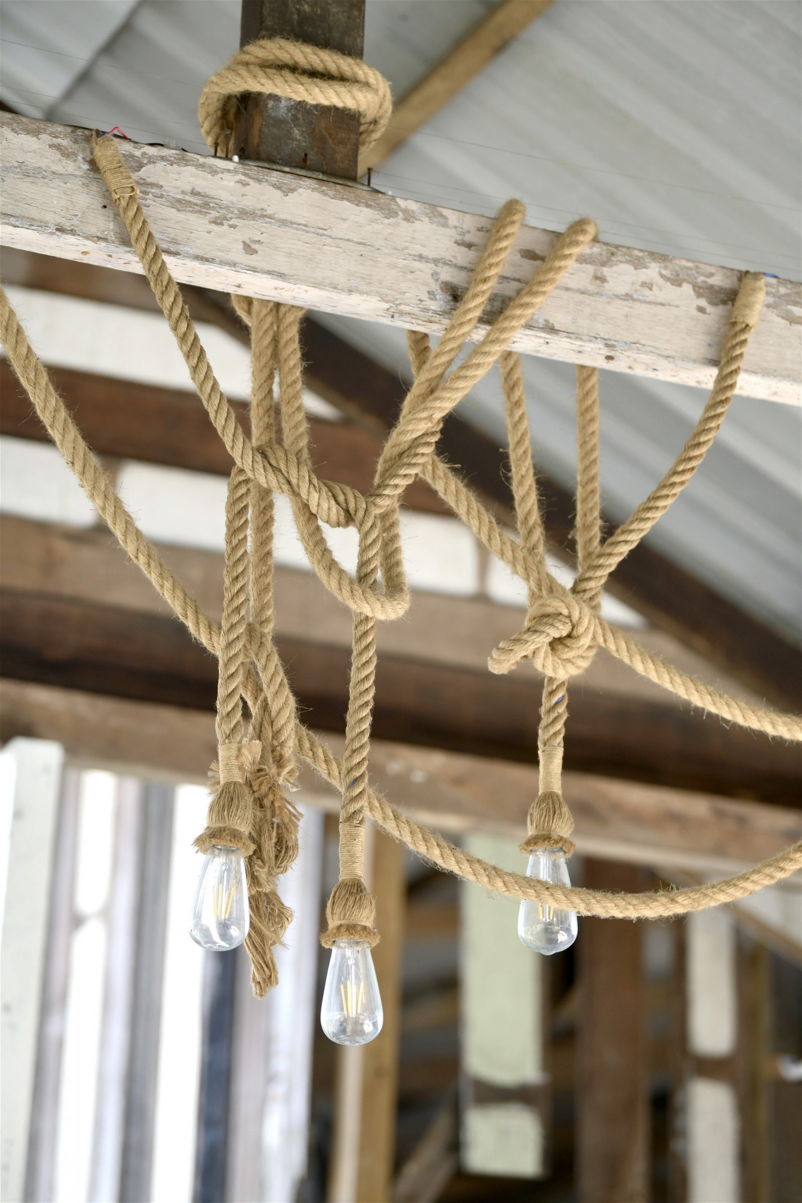 用麻绳悬绑在梁上的灯泡有著随性的艺术感。