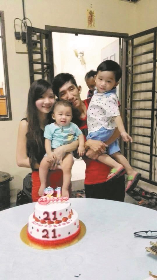 黄添财（左2）替妻子陈秀娟（左）庆祝21岁生日时，一家四口开心合照。