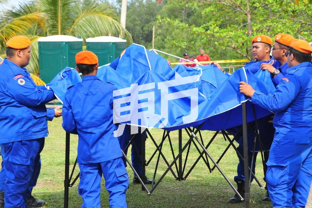 民防部队队员在现场搭起帐篷做好准备，以随时进行支援工作。（摄影：杨金森）