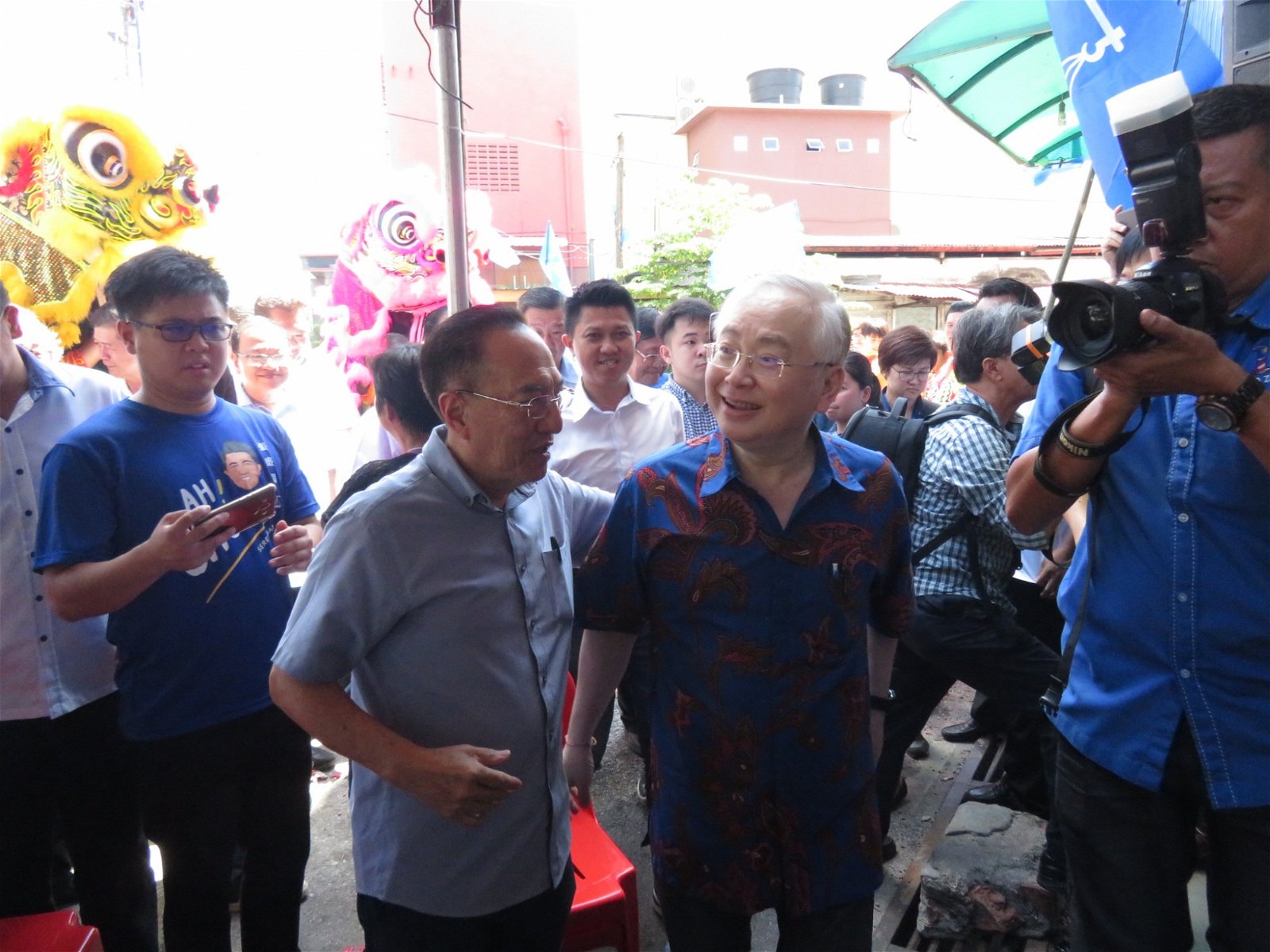 魏家祥（右）与前教育部副部长拿督韩春锦相见欢，2人一边走一边交换选情。