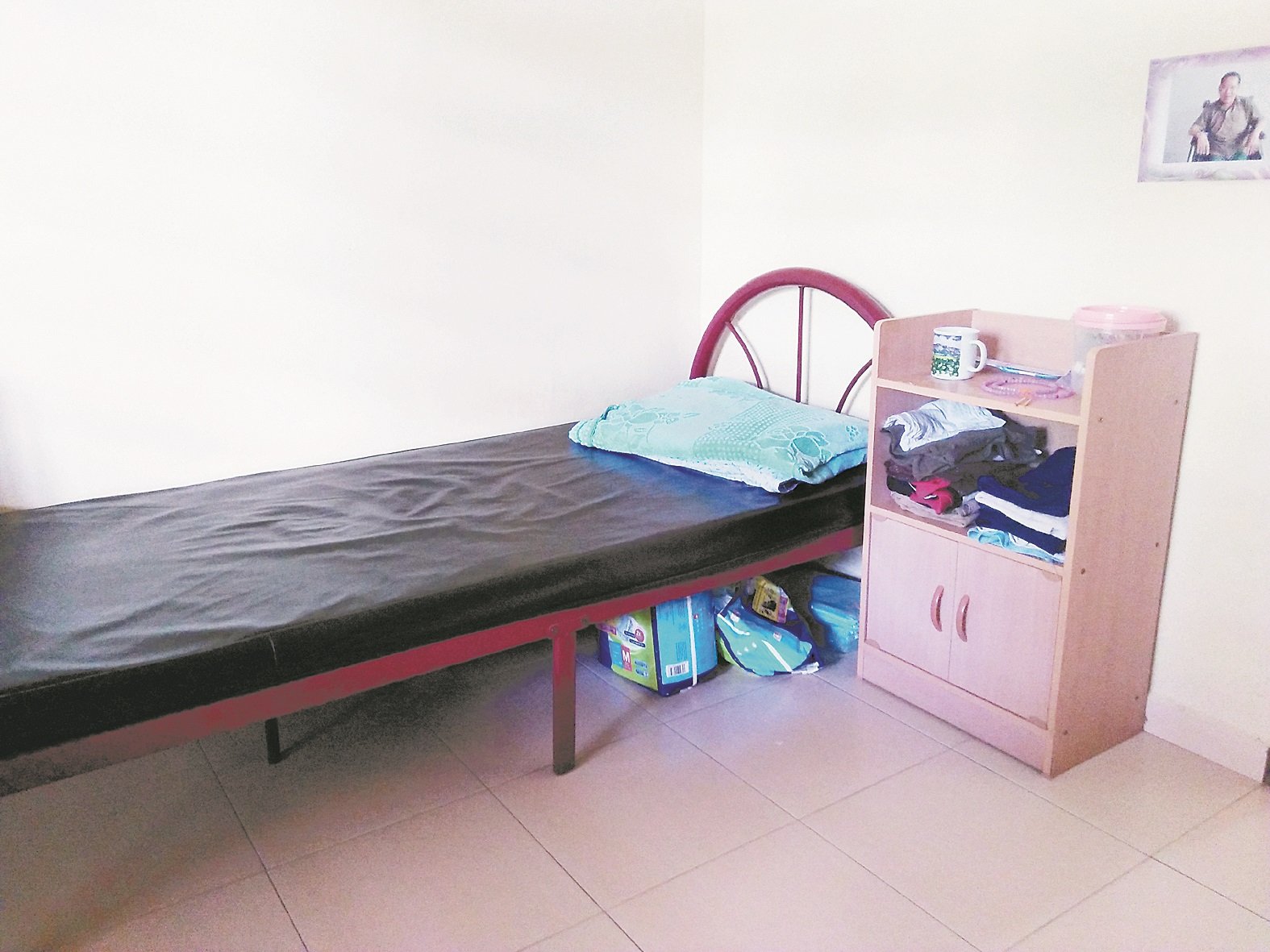 胡泽民入住爱心安养院，其床位只有几件简单的日常用品及衣物。