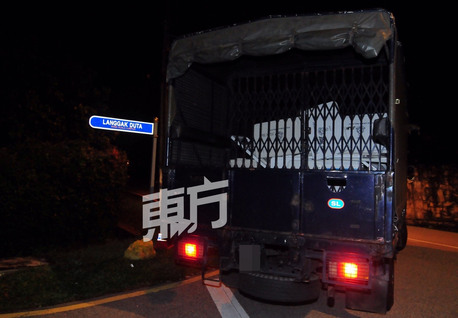 警方开著卡车到纳吉吉私邸前，搬下一些箱子。