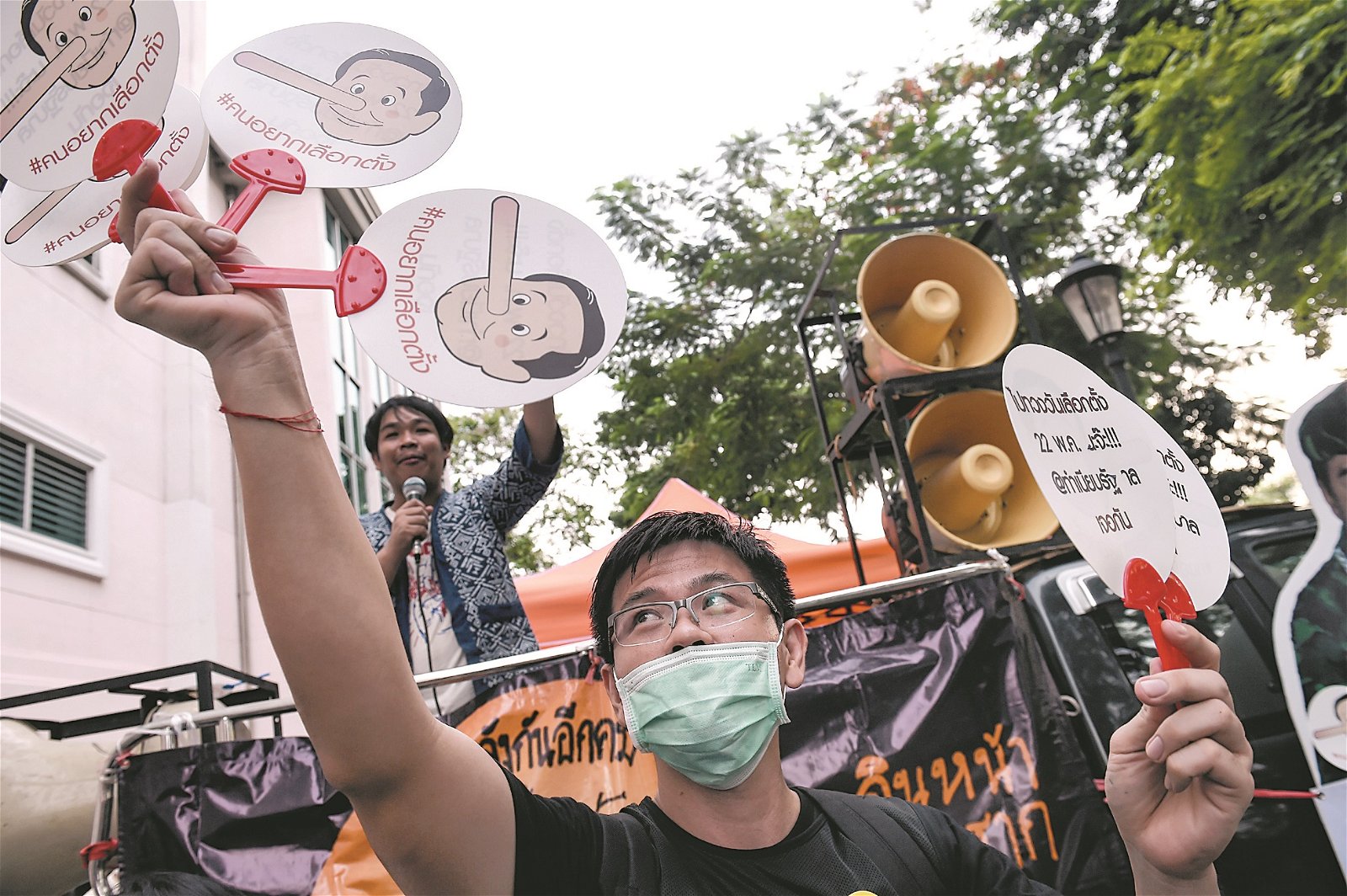 示威者在集会中，手举印有首相巴育卡通肖像的扇子，暗讽对方是鼻子长长了的骗子。