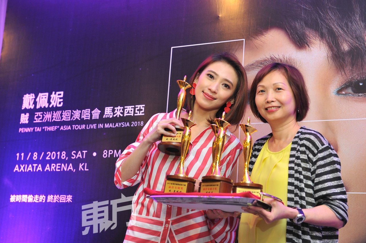 9 88高级节目总监林淑萍（右）在记者会上颁发《全球华语歌曲排行榜》的“最佳女歌手”、“最受欢迎创作歌手”、“最佳专辑”、“最佳专辑创作人”和“年度20大金曲”奖杯予戴佩妮。