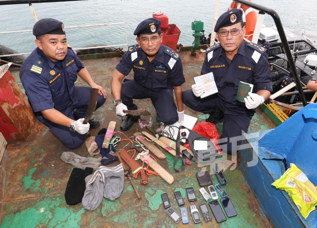 祖基菲里（左2）展示在遇劫油槽船搜查到的物品包括巴冷刀、毛巾、手套、手机及证件等。（摄影：刘维杰）