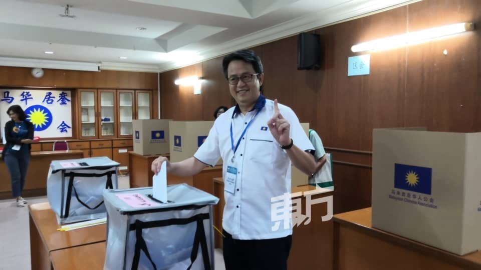 颜炳寿在投下选票时，不忘比出本身一号的竞选排位。
