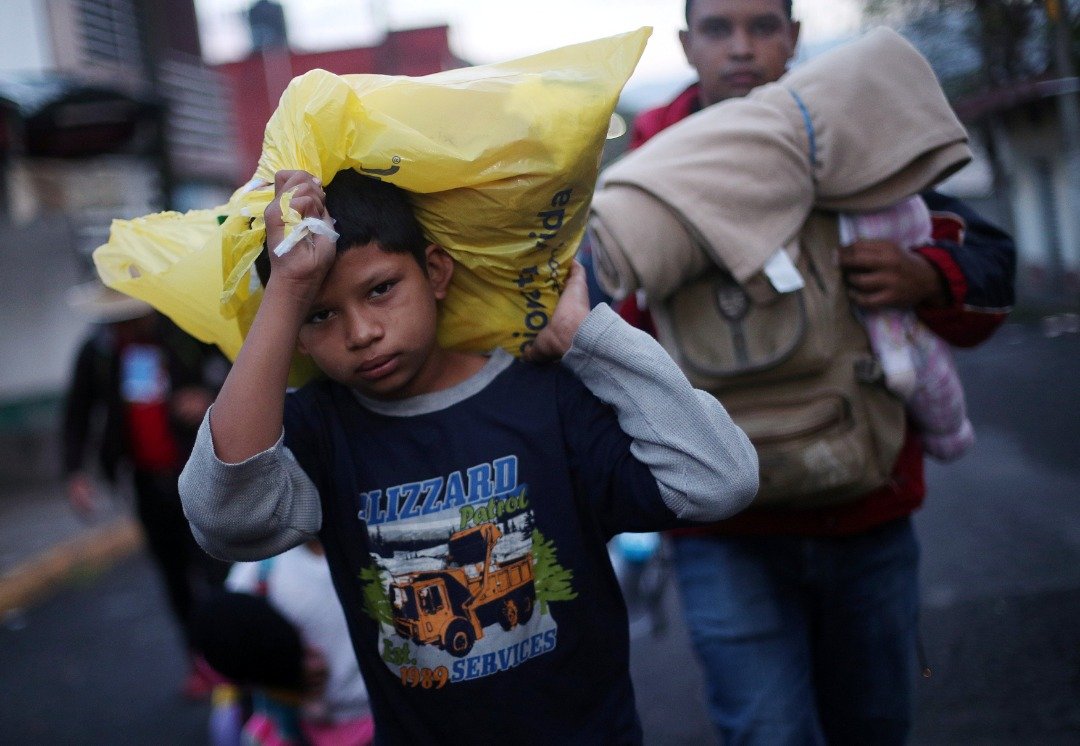 跟随家人加入移民大队的男孩，扛著自己的随身物品，从墨西哥南部的科尔多瓦，往墨西哥城前进。