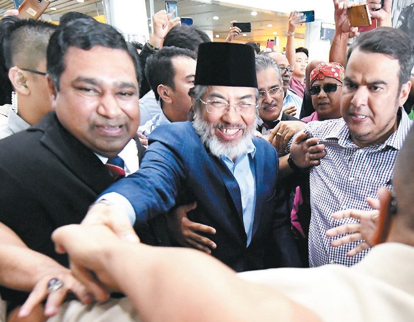 慕沙阿曼（中）从吉隆坡飞抵亚庇以聆听首长双包案裁决，在亚庇机场受到近百名支持者欢迎。