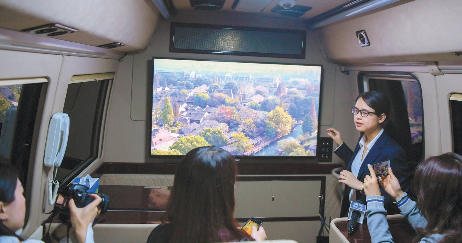 浙江移动乌镇分水墩营业厅外，工作人员在一辆体验巴士内，介绍通过5G移动传输技术实现的8K高清的视频画面实时展示。