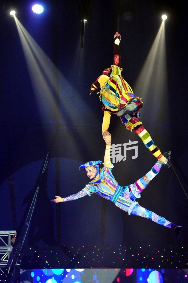 男女表演者穿上俄罗斯娃娃传统服饰，表演空中飞人的项目。