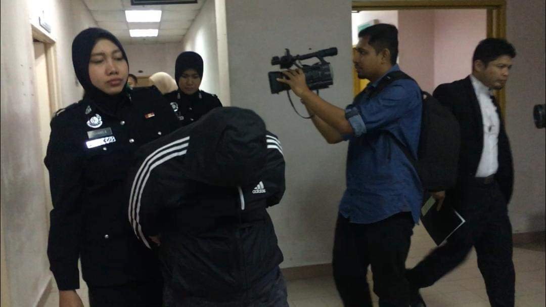 陈玉莹（译音）抵达法庭后，低头并以外套闪避媒体镜头。