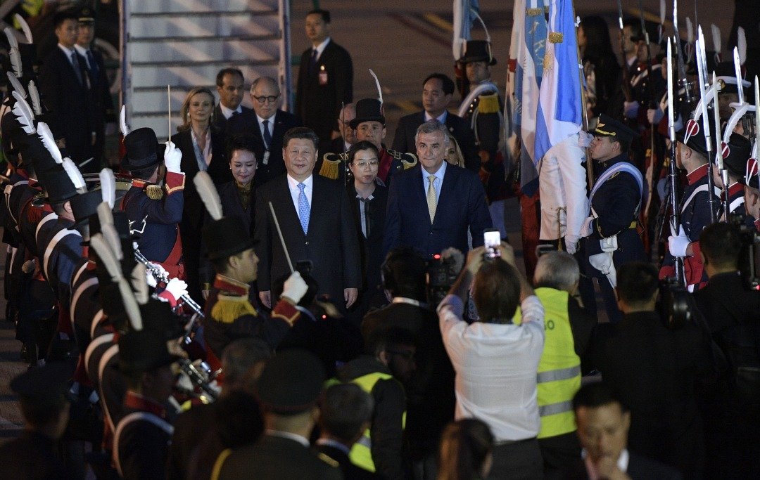 中国国家主席习近平（前排左2）和夫人彭丽媛，当地时间周四晚乘坐专机，抵达布宜诺斯艾利斯的埃塞萨国际机场。胡胡伊省省长莫拉莱斯（前排右）率领官员到机场迎接，现场还有仪仗队列队欢迎。