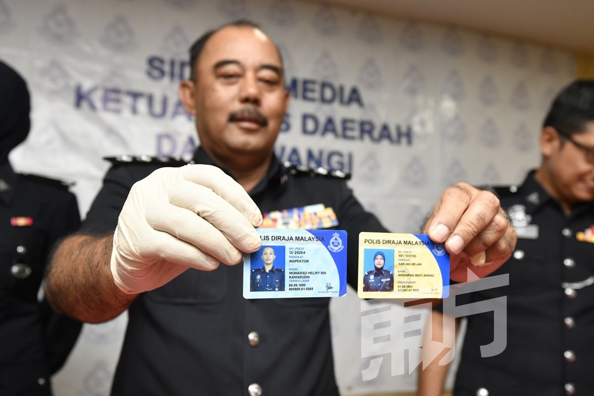 沙哈鲁丁展示两张正规的 警员证，左为警阶是见习 警长以上的蓝色警官证， 右为警阶是普通警员以上的黄色警员证。 （摄影：伍信隆）