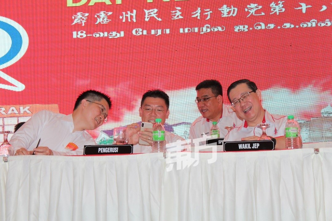 倪可敏（前左2）在代表大会上与林冠英（右）互动甚密，2人看了手机后笑呵呵，黄家和（左）也好奇地趋前观看。
