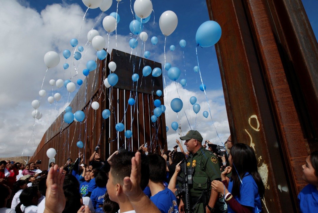 儿童们在“要拥抱不要城墙”团聚活动中，释放了蓝白色的气球，让其飘向天空。该团聚活动始于2016年秋季，此后就一直帮助约数千户分隔两地的家庭重新相聚在一起。
