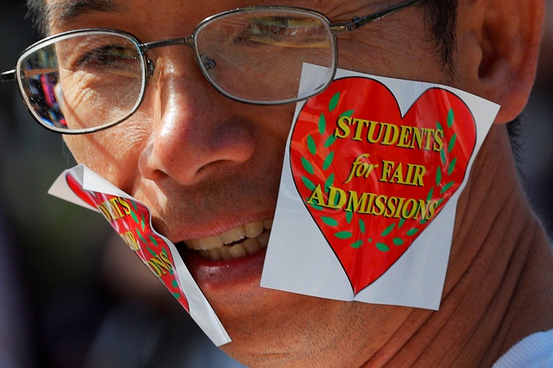 一名参与集会的亚裔男子在脸上贴上支持“大学生公平录取”（SFFA）组织的贴纸。