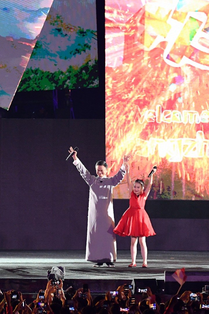 身穿唐装的马云（左），周日与一穿著红色衣服的杭州小女孩同台亮相，为雅加达巨港亚运会闭幕仪式上的“杭州8分钟”进行表演，与全亚洲人民相约4年后再见。