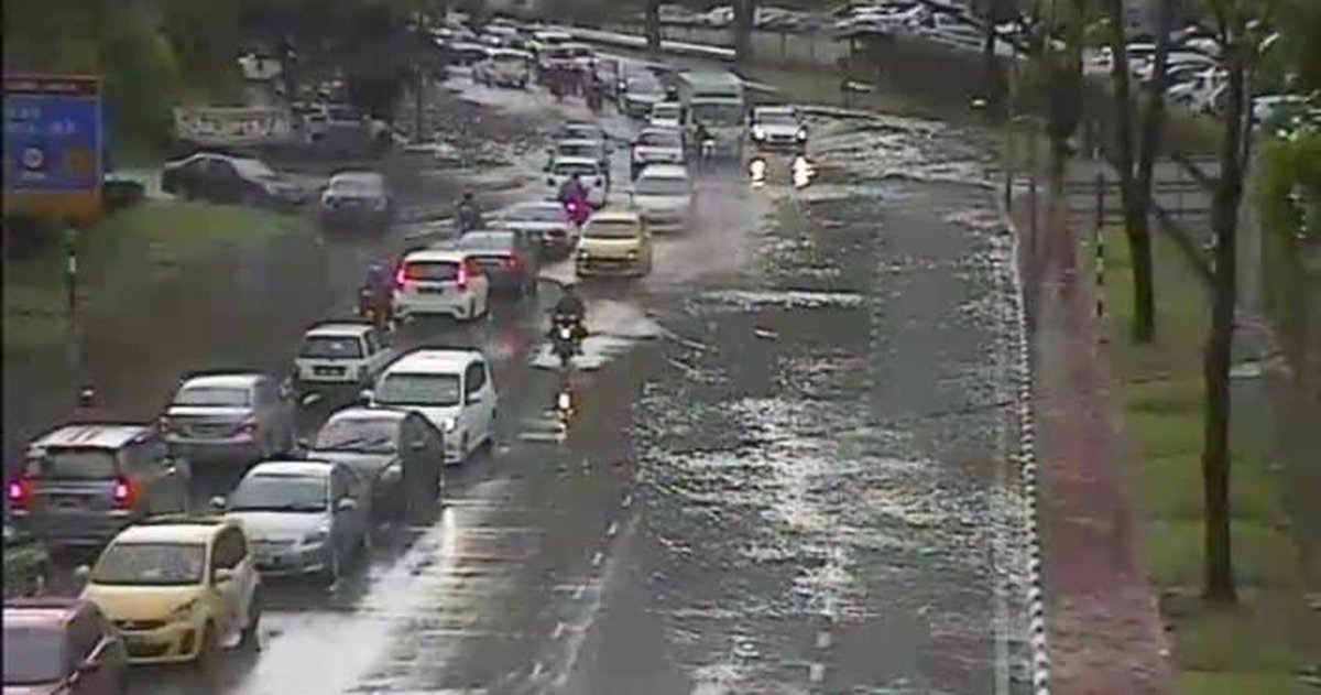 雨水已积满其中一个方向的两个车道，导致周五早上经过槟城天德园大道的车辆只好“共用”同一个方向的车道，形成交通大混乱。