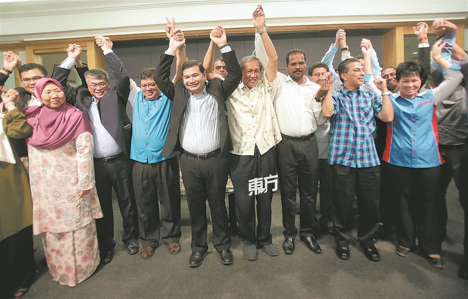 拉菲兹竞选团队在誓师大会上，共同高举双手示意。左起傅芝雅、梁自坚、佐哈里阿都、拉菲兹、依德里斯阿末、柯洁文、赛依布拉欣和廖书慧。（摄影：骆曼）