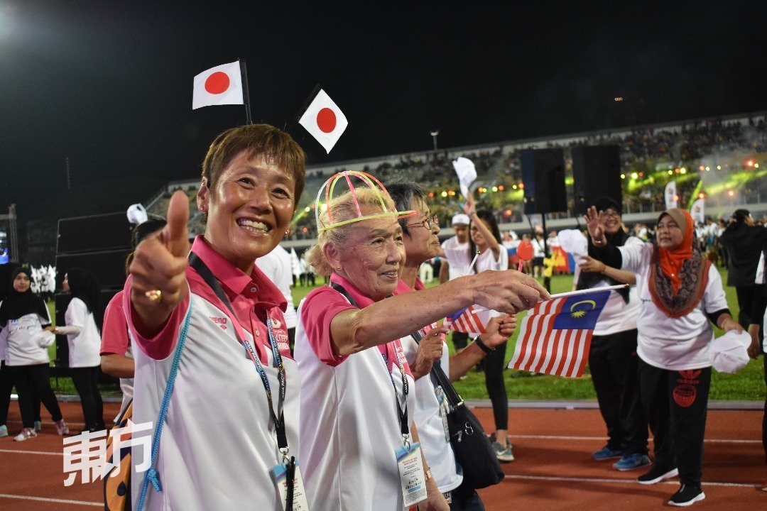 来自日本的运动员代表在开幕礼上向现场民众挥手登场。