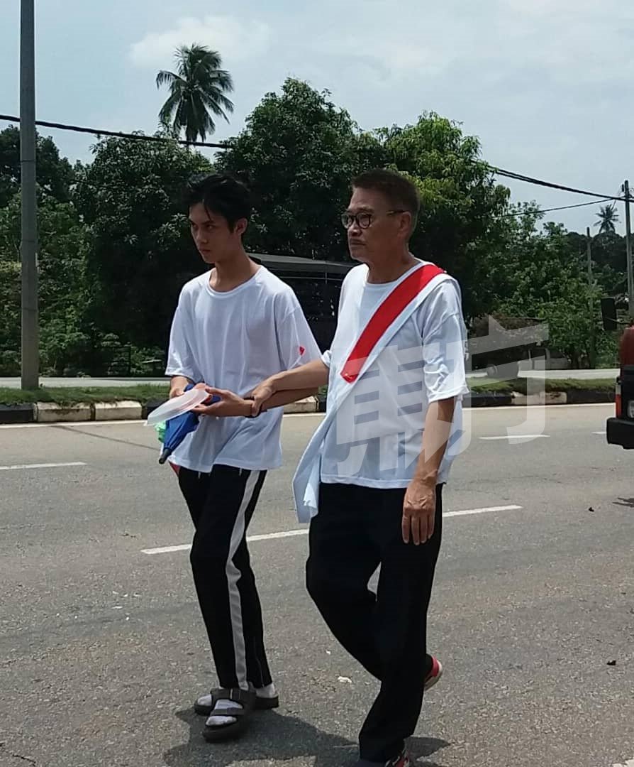 吴孟达（右）在儿子吴韦仑陪同下，步行400米送岳父最后一程。
