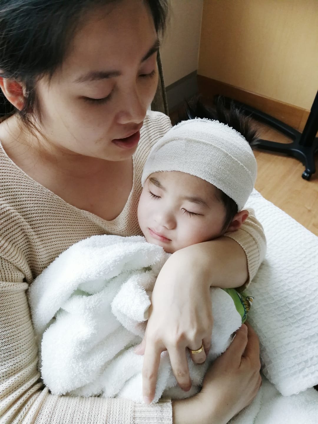 手术结束后，小乙成苏醒过来，被母亲黄家宝抱在怀里。