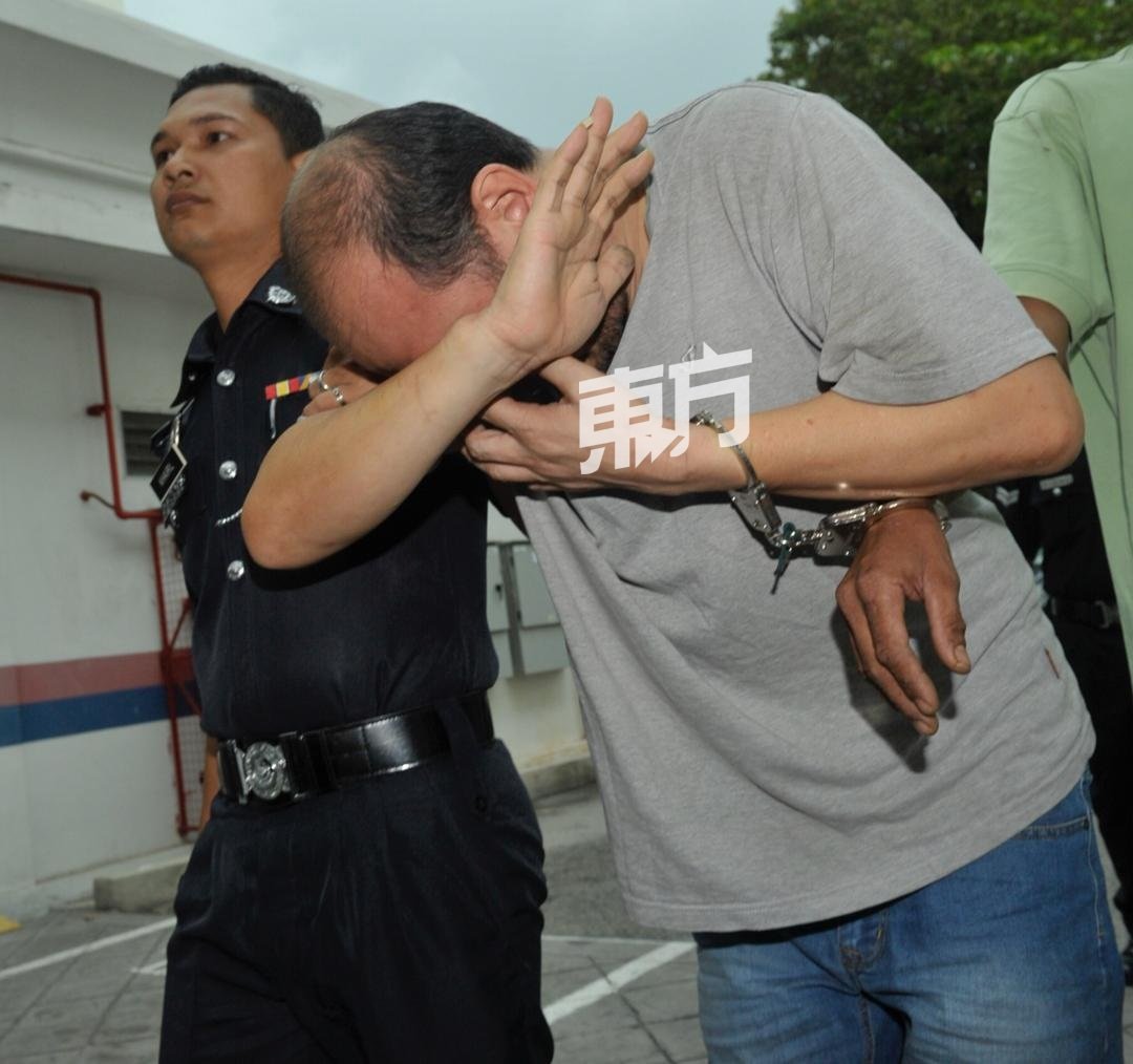 涉及自1996年来全马最大宗毒品案的华裔被告黄文龙（译音）周四被押上庭时，全程用手遮脸，避免真面目曝光。（摄影：蔡开国）
