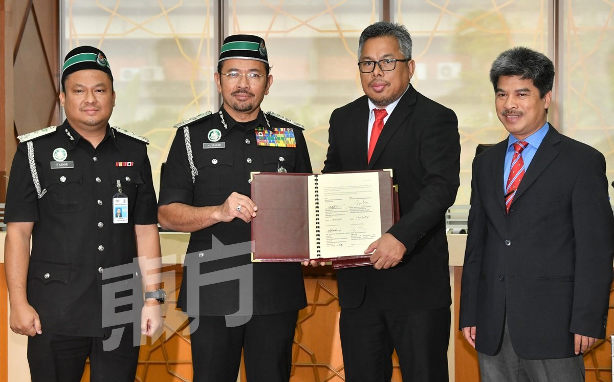 慕斯达法（左2）与国民大学副校长罗斯里（左3）签署合作谅解备忘录。左起为移民局政策和策略规划组主任沙哈米，以及国大马来西亚和国际研究所副主任苏菲安。（摄影：张真甄）