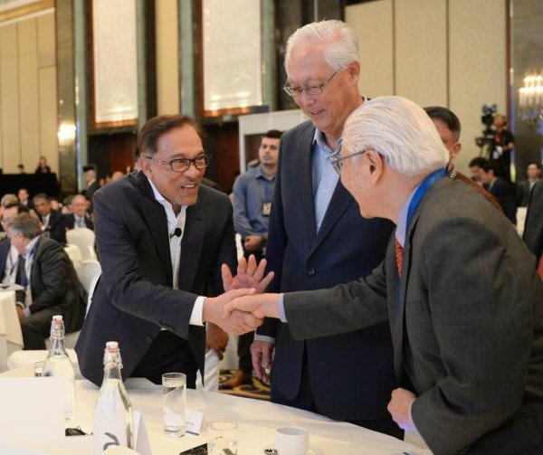 安华（左）在峰会上，与新加坡前总统陈庆炎（右）相见欢。中为新加坡前总理吴作栋。