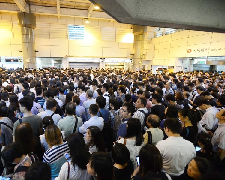 风灾过后，由于香港政府未宣布停工，许多上班族周一仍要赶上班，但台风令路轨和架空电缆受损，东铁线几近瘫痪。图为大埔墟站大批乘客排队，现场几乎挤得水泄不通。