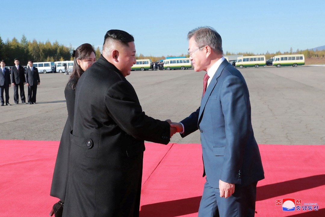 朝中社周五报导韩国总统文在寅（右）访问朝鲜，以及与最高领导人金正恩（左2）登上白头山的消息。这是文在寅周四在三池渊机场，准备飞回首尔，金正恩亲自送机，与他握手道别。