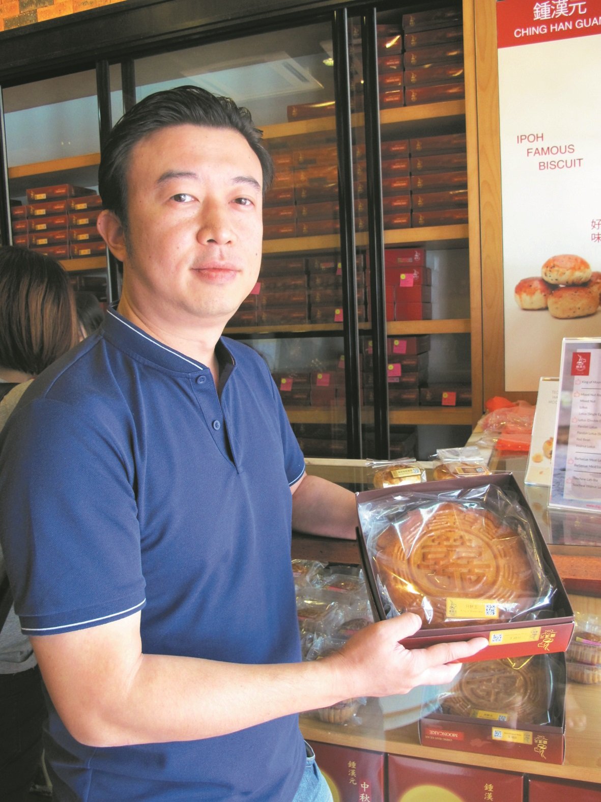 钟思明手中的“月饼王”重超过1公斤，是该店的招牌月饼之一。