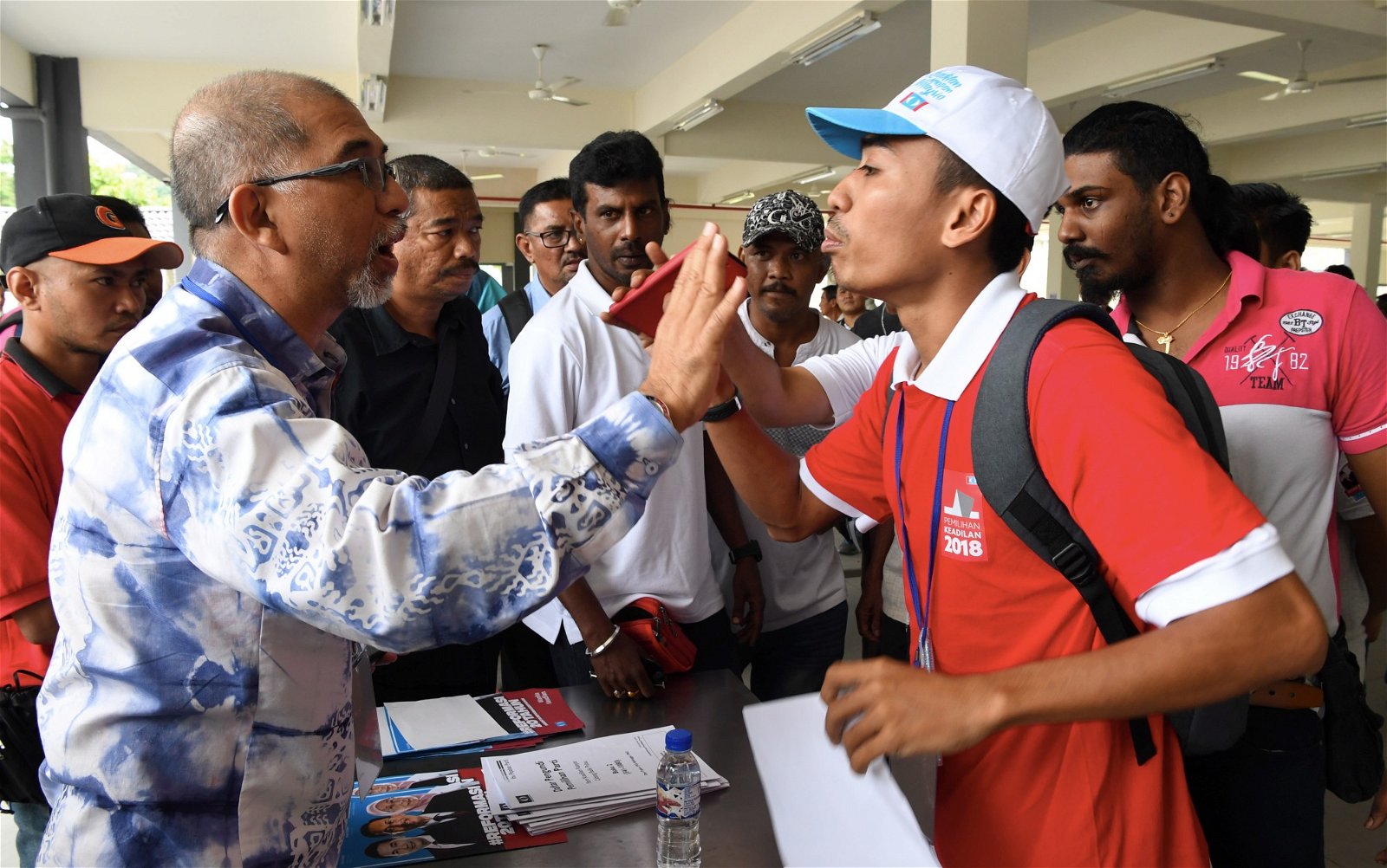 来自公正党的旅游部副部长莫哈末峇迪亚（左），准备在槟城浮罗山背一个投票中心投票时，发现其名字竟没在选民册内，一度引起他的不满。不过，他较后已顺利投票。