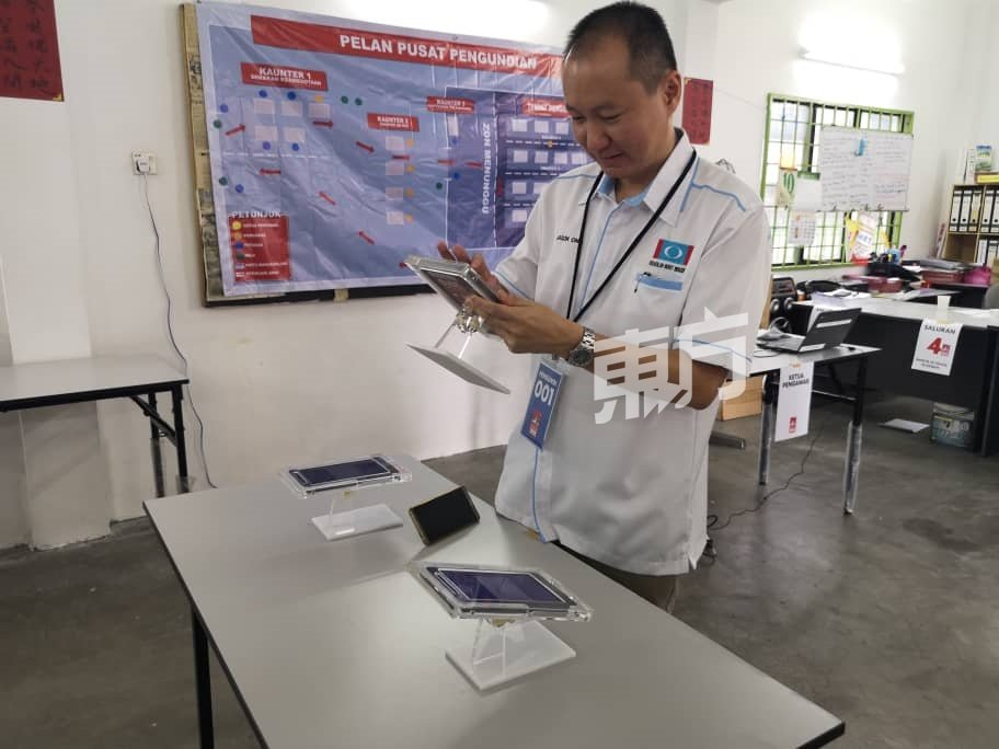 在槟公正党升旗山区部投票站的电脑系统成功连线后，王康立是第一个投票的党员。（摄影:吴维康）