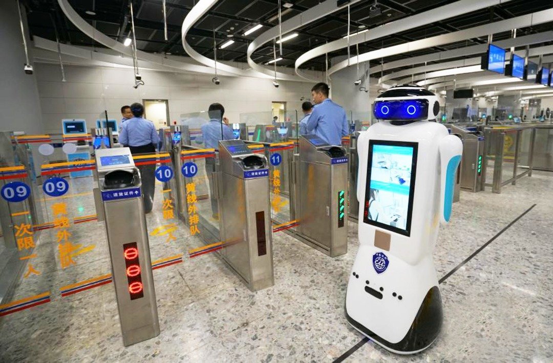 高铁香港西九龙站“一地两检”内地口岸区，边检机器人来回移动，胸前的显示屏不断播出出入境自助查验系统的使用方法。西九龙站实施的“一地两检”通关程序，缩短了乘客通关时间。香港口岸区和内地口岸区，由双方分别按照各自法律，对乘坐高铁往来内地和香港的人士及随身物品和行李，进行出入境监管查验。