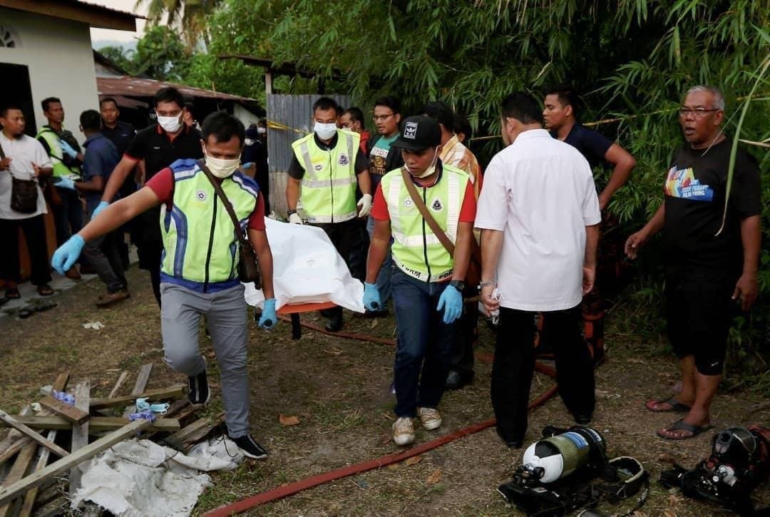 警员抬出死者遗体，送往槟城中央医院太平间解剖查明死因。