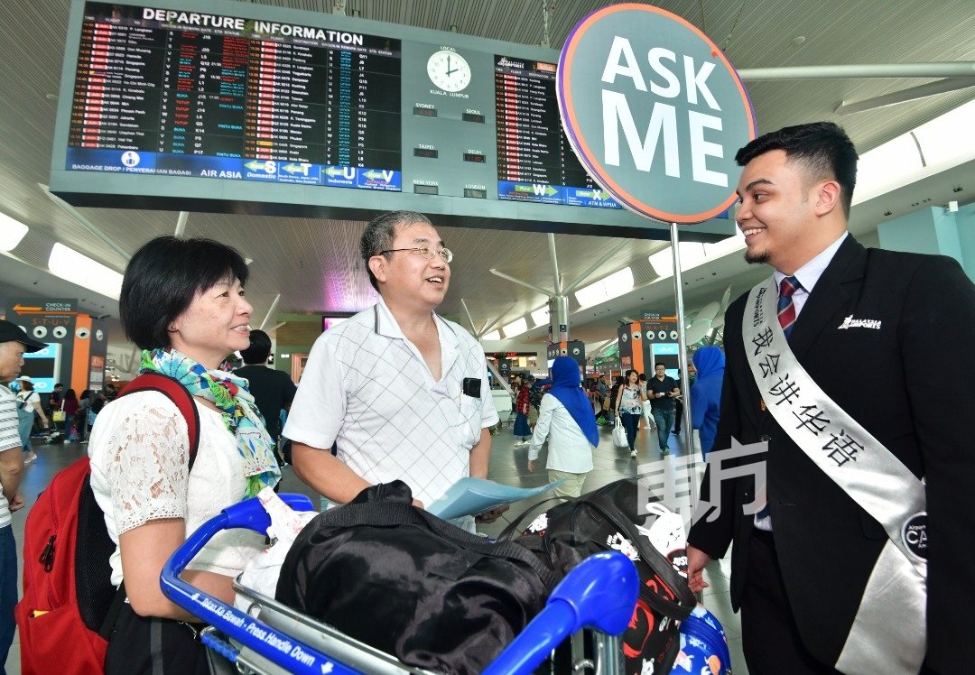 “我会说华语”，能口操流利华语的机场服务人员希达雅（右），协助来自香港的旅客张国华（63岁）及妻子。（摄影：张真甄）
