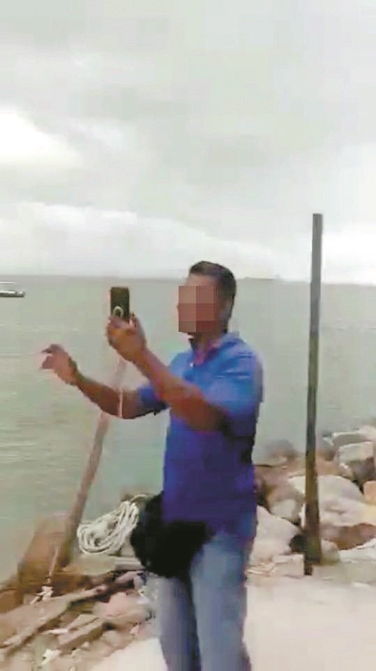丹绒道光海域出现水龙卷奇景，有民众见状， 立刻拿起手机拍摄，而不是逃离现场。