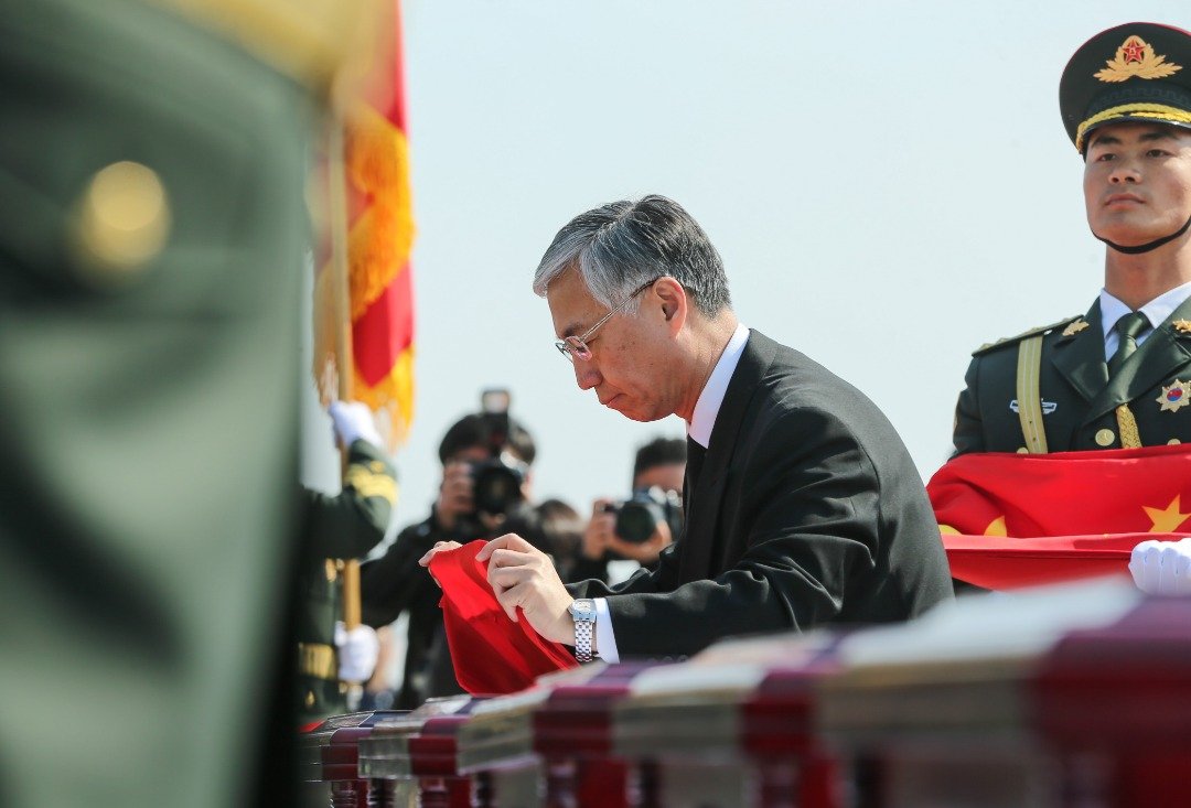 国旗盖棺：中国驻韩国大使邱国洪，为志愿军烈士遗骸棺椁，盖上中国国旗，致以最高的敬意。