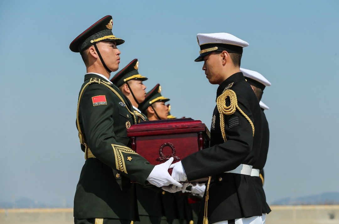中韩交接：韩国仁川国际机场举行的交接仪式上，韩国官兵（右）将中国人民志愿军烈士遗骸，交到中方礼兵手中。