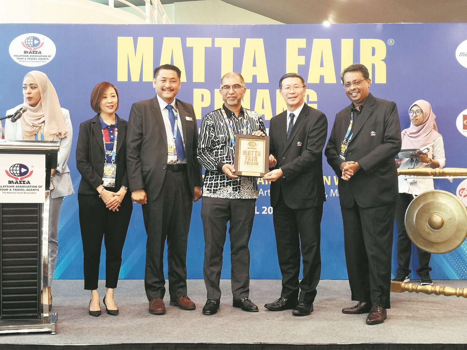 在马来西亚国际旅游展槟 城站的开幕仪式上，陈国良 （右2）颁发纪念品予莫哈 末峇迪亚（左3）。