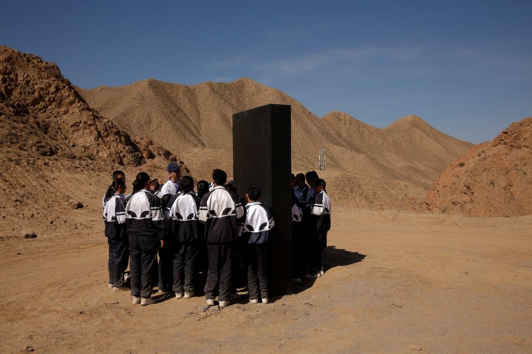 学生们在“火星1号基地”学习火星知识，他们围绕在一个代表火星物质的黑色石板，用心地听工作人员讲解。-路透社-